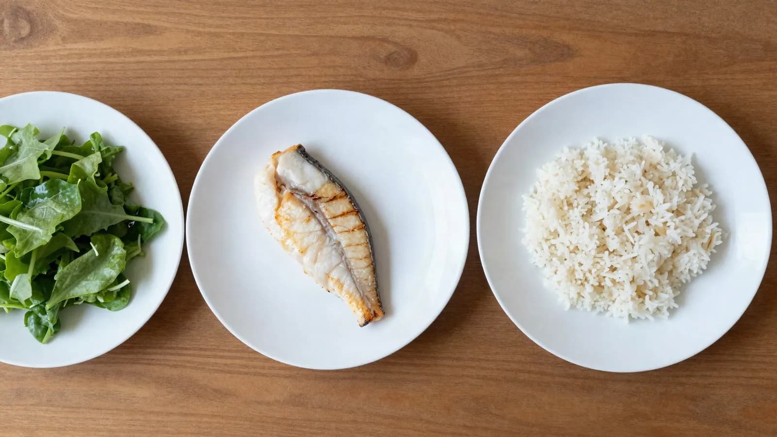 Three plates in sequence: salad, then grilled fish, then rice