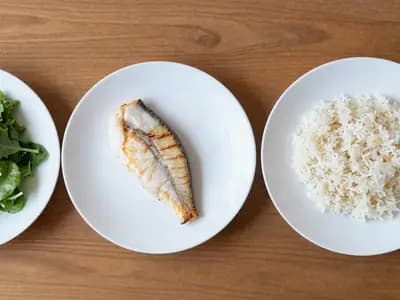 Three plates in sequence: salad, then grilled fish, then rice