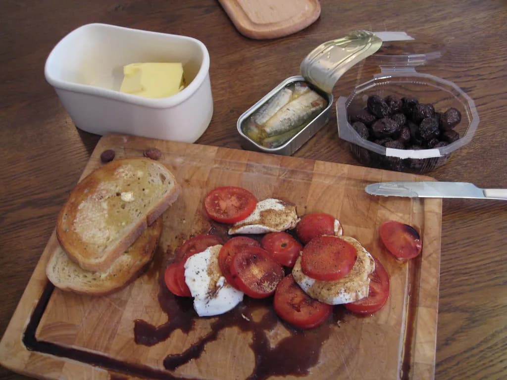 Mediterranean-style meal arrangement featuring olive oil, fresh vegetables, whole grains, and grilled fish