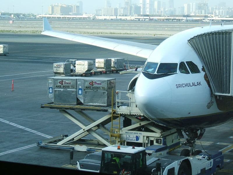 Passengers checking a departure board during disruption at a major airport