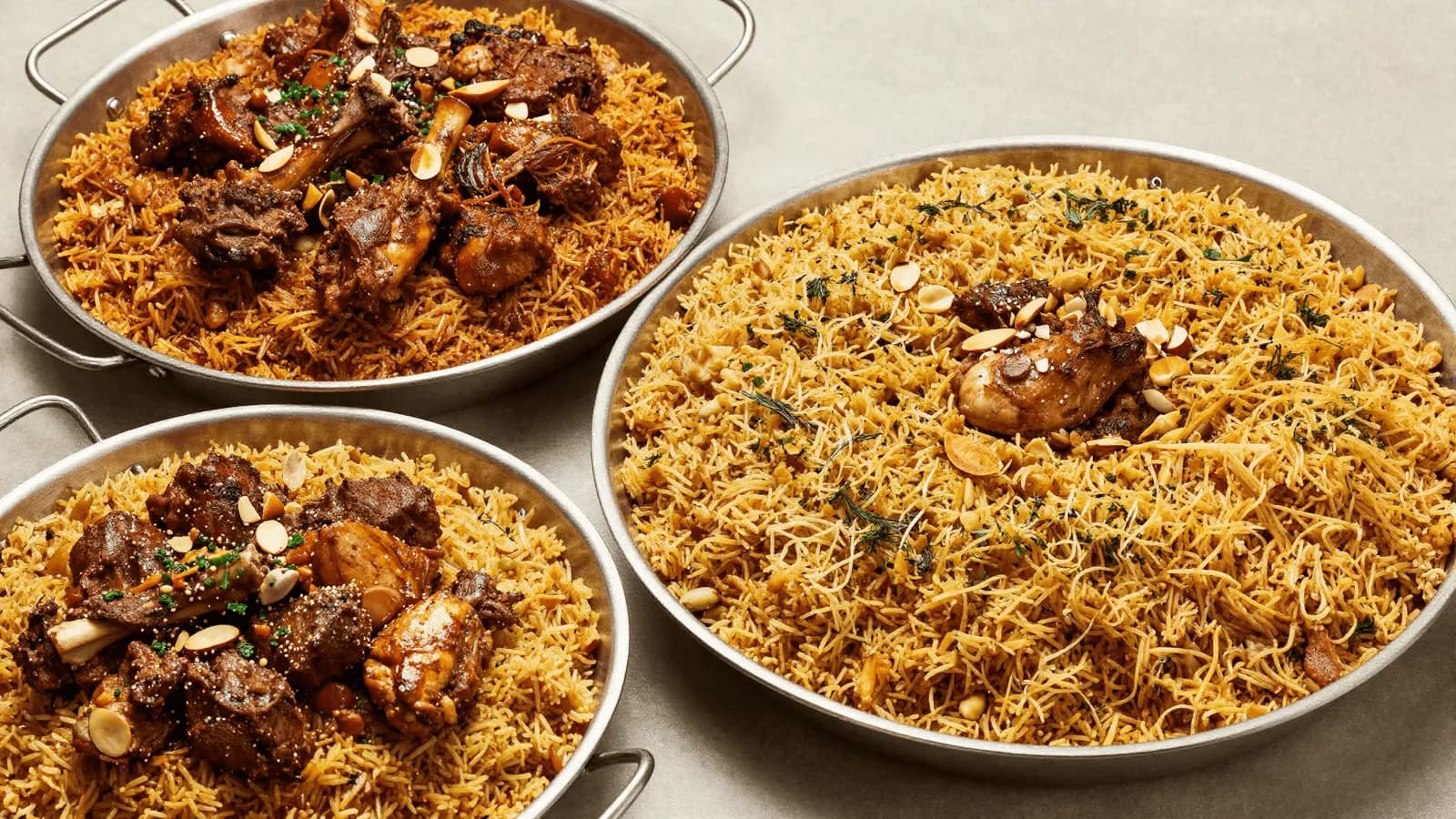 Platters of spiced rice dishes set out together on a table