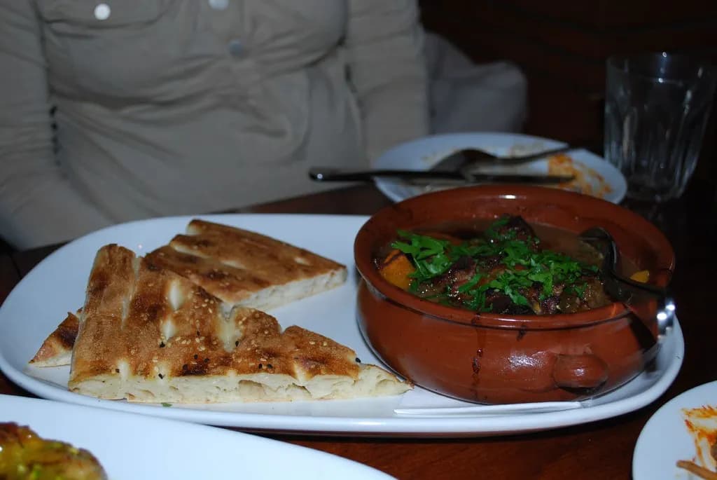 Traditional Moroccan chicken tagine with tender chicken, preserved lemon, green olives, and aromatic spices served over fluffy couscous