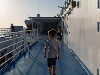 A passenger on the open deck of the ferry Blue Star Myconos crossing the Icarian Sea in Greece, September 2024