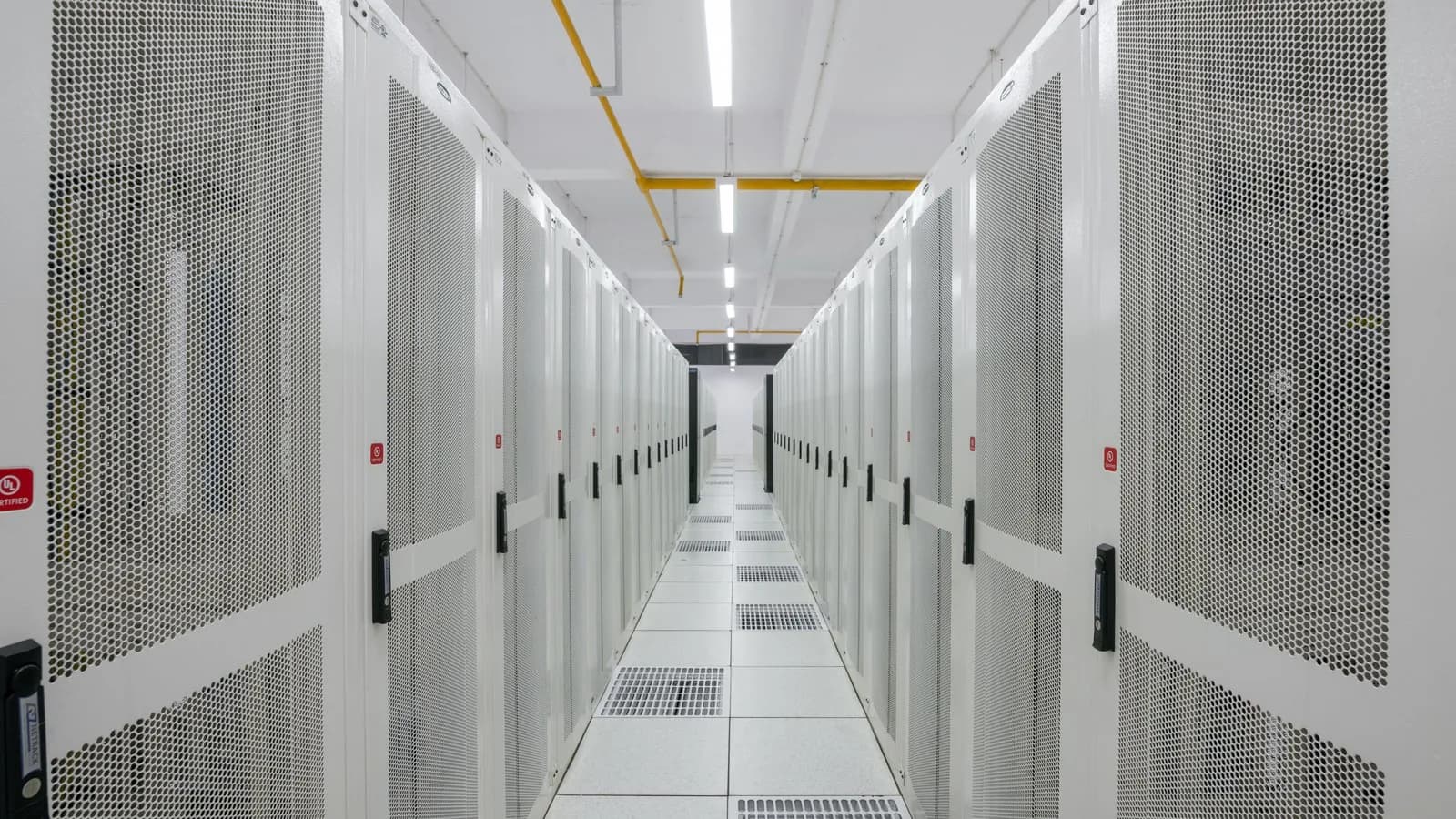 An aisle between rows of server racks in a data centre