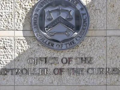 The seal and lettering of the Office of the Comptroller of the Currency on a stone wall outside its headquarters at 400 7th Street SW in Washington, photographed on 10 February 2025, a file photograph of the agency's sign and not of the rule's release