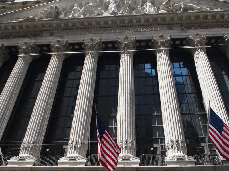 The columned facade of the New York Stock Exchange on Broad Street, hung with American flags