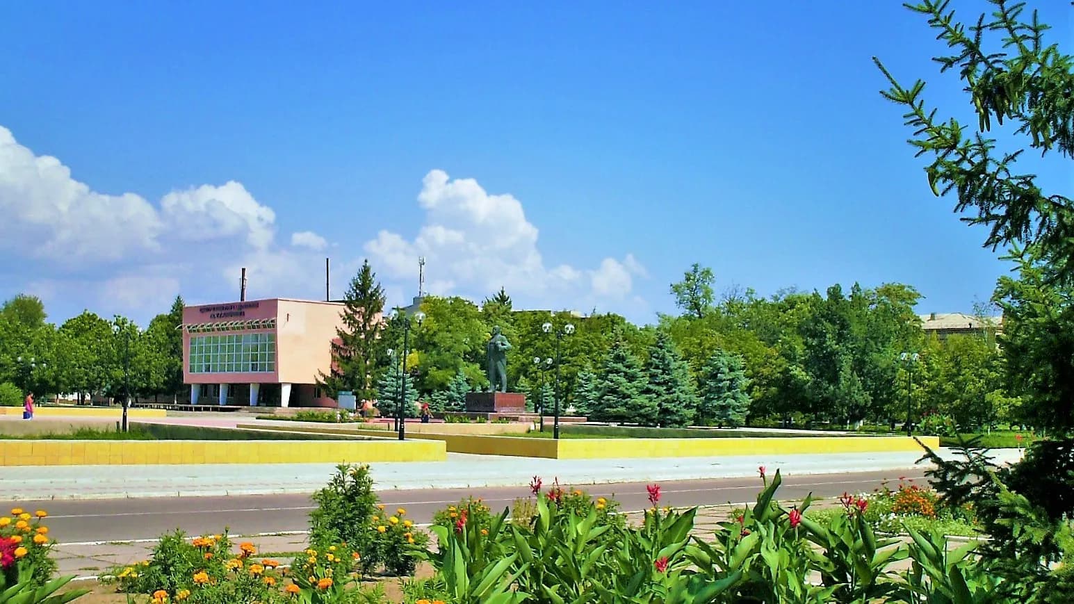 Central Square of Oleshky with a low administrative building, trees and flower beds under a blue sky, photographed on 14 August 2007, a file photograph of the town and not of the present situation