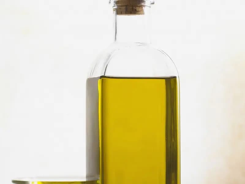 A glass bottle with a cork stopper filled with golden extra-virgin olive oil against a pale background, photographed on 21 June 2005, a file photograph illustrative of olive oil and not of the Kyoto study