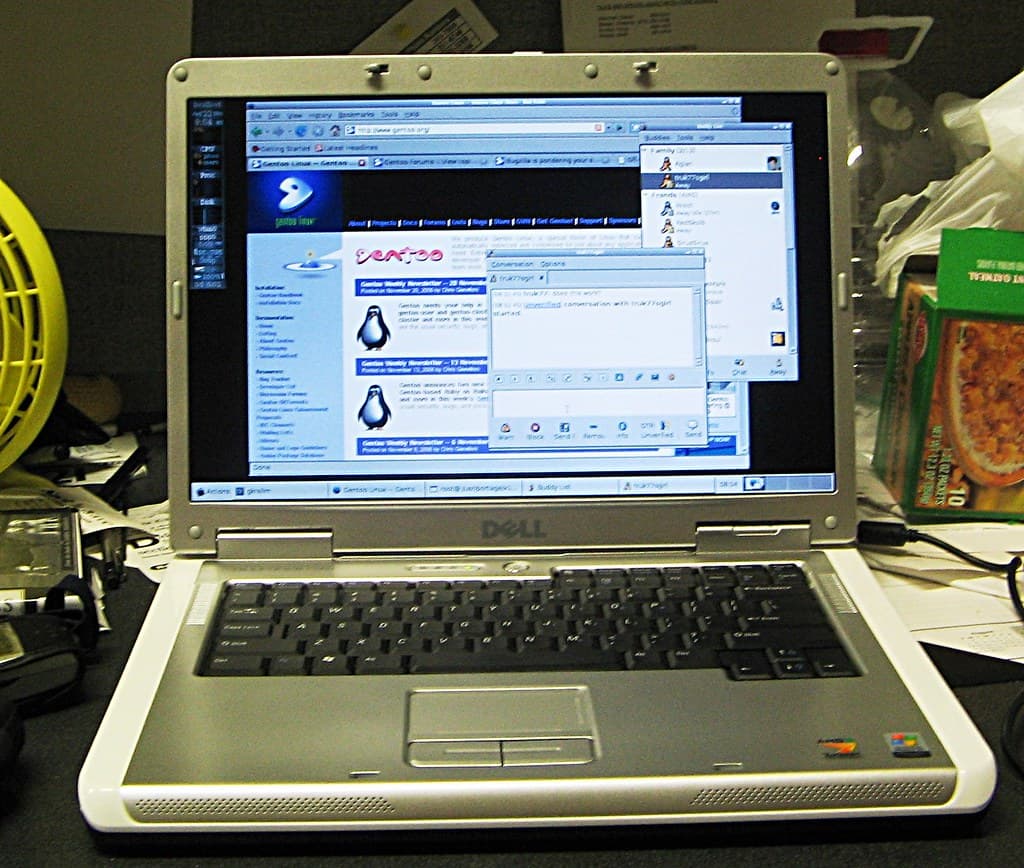 A laptop screen glowing in a dim room, displaying a conversational AI chat interface mid-response.