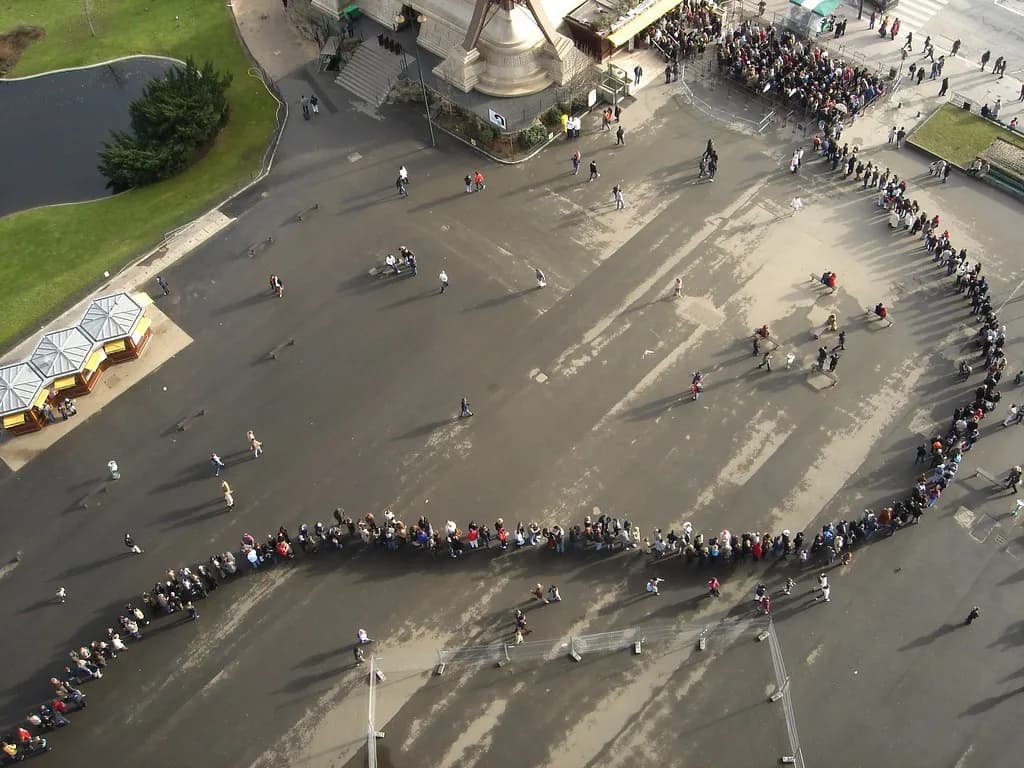 An Olympic venue built beside a famous Paris landmark with crowds watching a daytime event