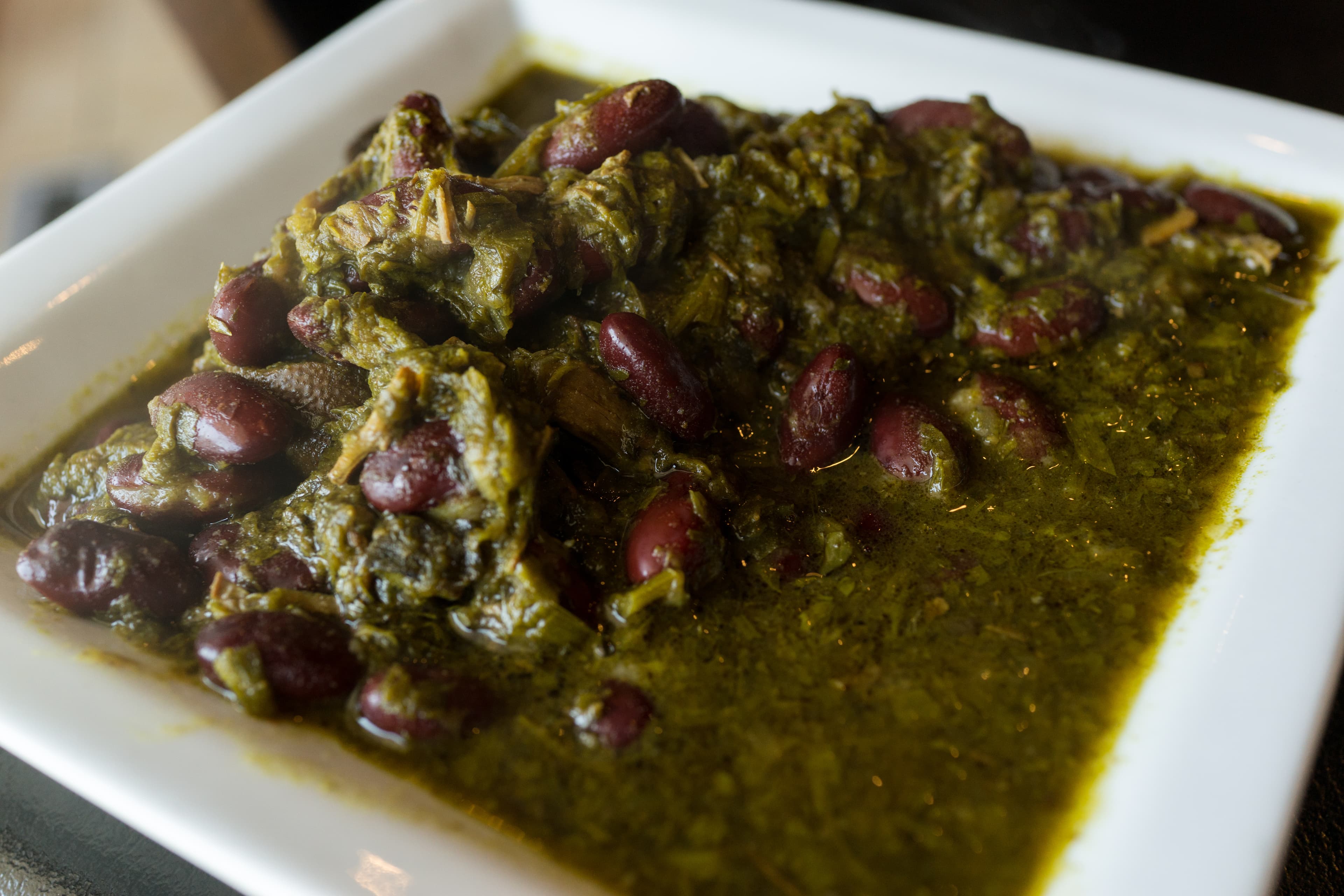 Bowl of fragrant Persian ghormeh sabzi stew with tender meat, kidney beans, and fresh herbs served over golden saffron rice