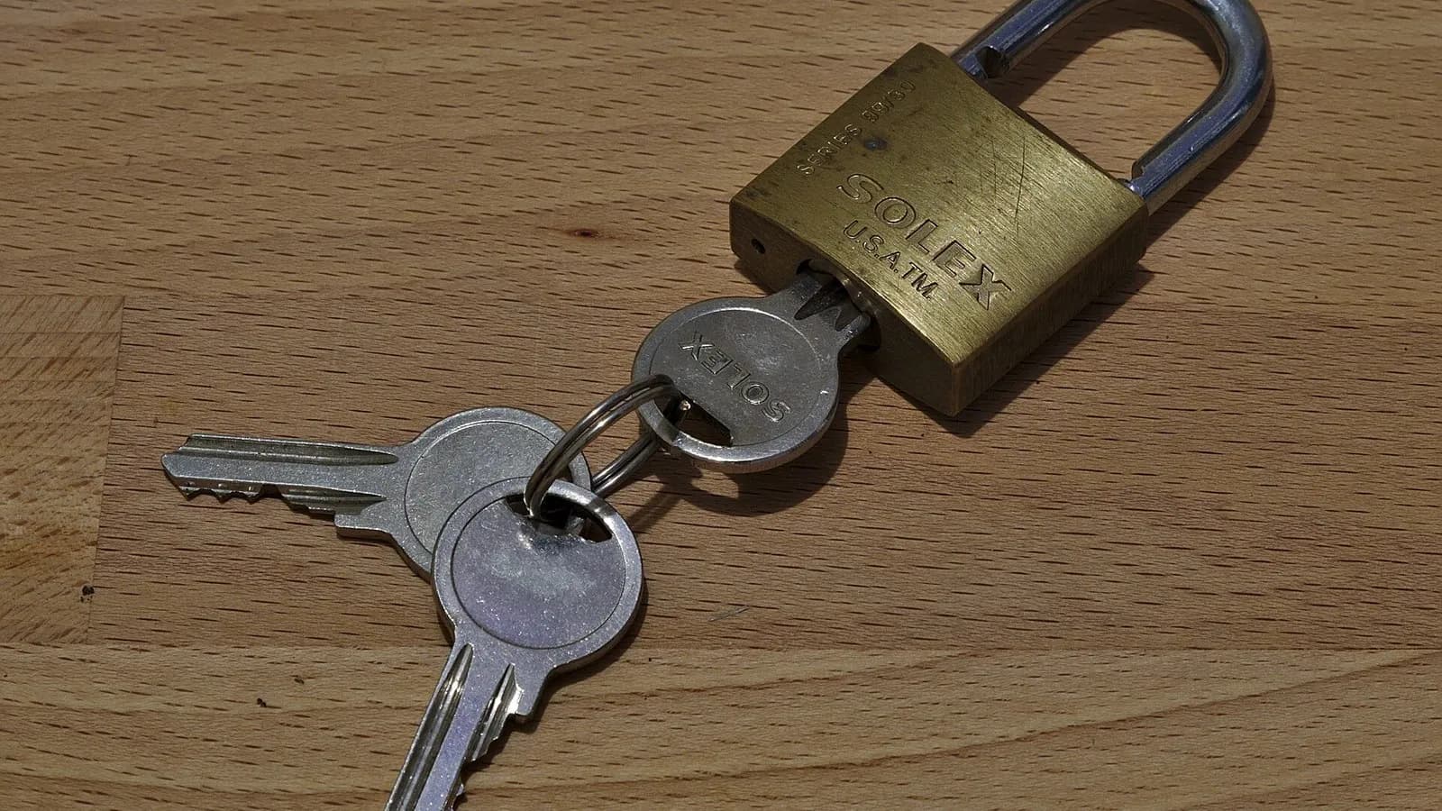 A brass padlock beside a pair of keys on a wooden table, photographed on 16 January 2018, a file photograph illustrative of security and not of PHP or anything in the story