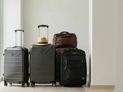 Packed suitcases and a travel bag standing ready in a bright hallway