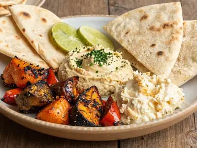 A plant-based Gulf plate of roasted vegetables and hummus