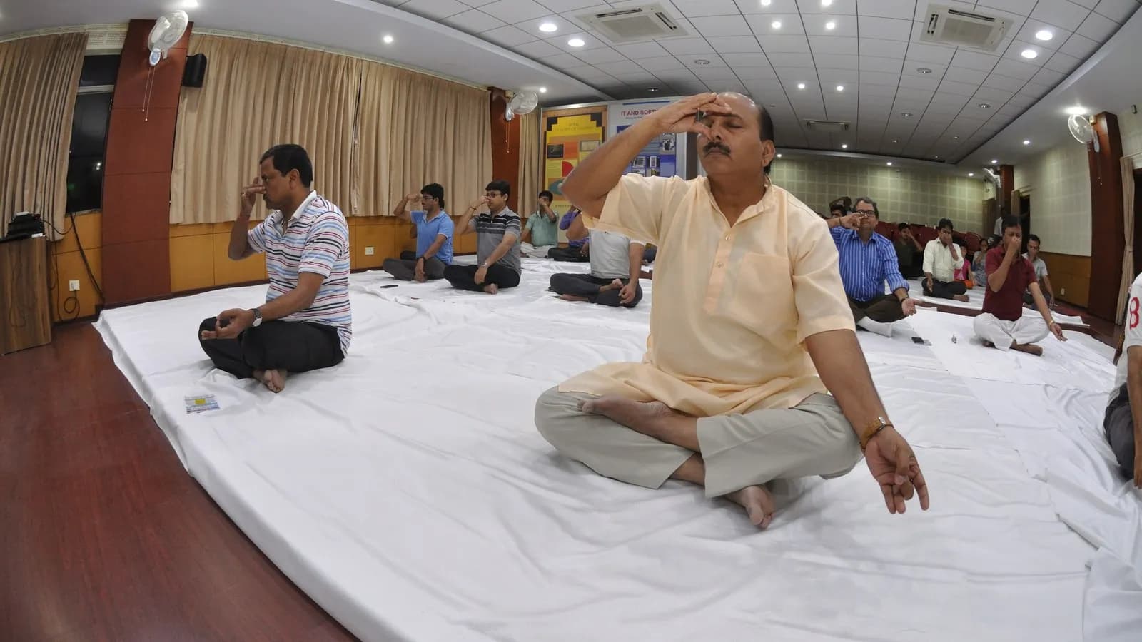 Participants seated on the floor practising nadishodhana, alternate nostril breathing, at an International Day of Yoga event in Kolkata in 2017