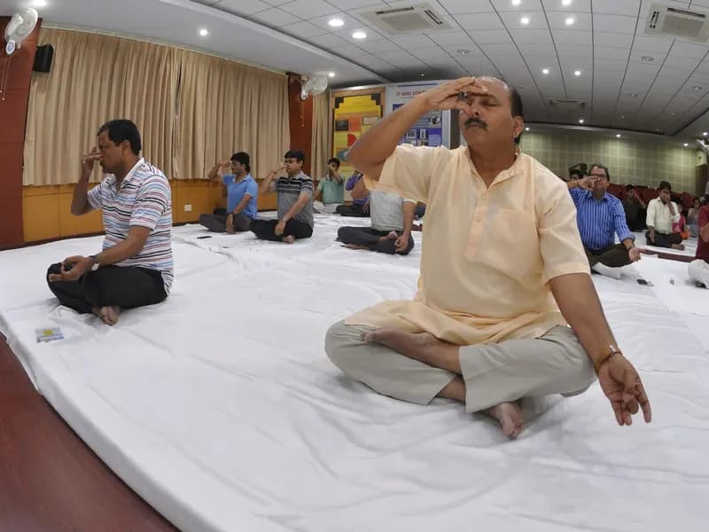 Participants seated on the floor practising nadishodhana, alternate nostril breathing, at an International Day of Yoga event in Kolkata in 2017