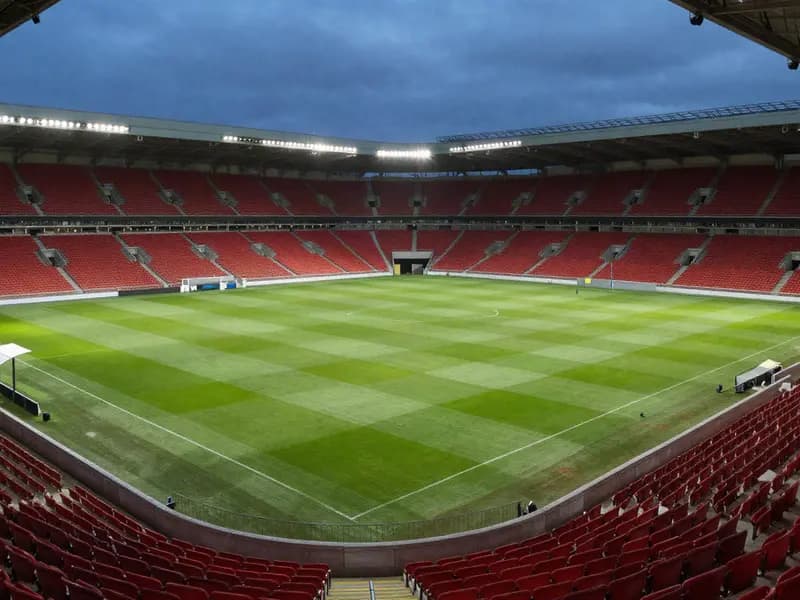A floodlit football stadium in the evening before kick-off
