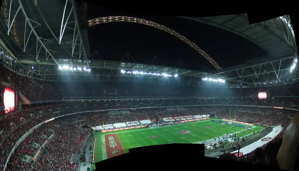 A packed football stadium under floodlights