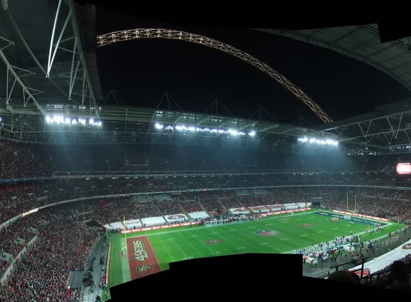 A packed football stadium under floodlights