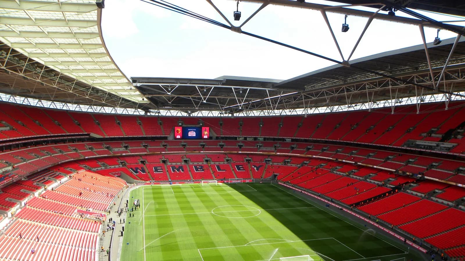 The interior of Wembley Stadium, looking across the pitch to the empty stands