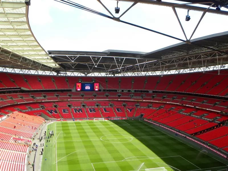 The interior of Wembley Stadium, looking across the pitch to the empty stands