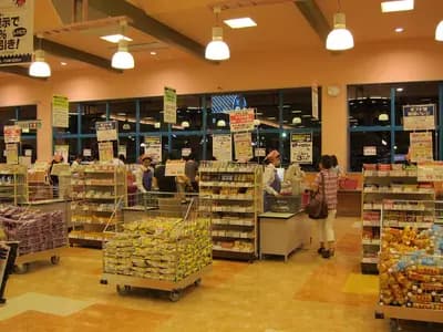 Brightly lit grocery store aisle with multiple brands of high-protein cereal, bars, and snack products