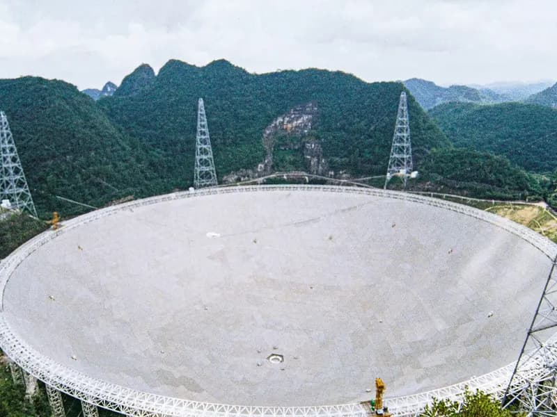 The 500-metre FAST radio telescope dish in its forested karst valley in Guizhou, China, photographed on 10 August 2025, a file photograph of the telescope that observed the pulsar and not from this week
