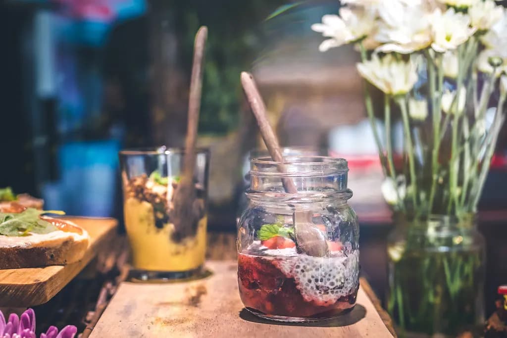 A bright vegan cafe interior on the Pearl Qatar with a granola bowl and smoothie on the counter