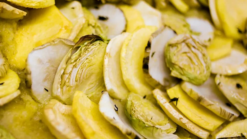 Arranged accordion-style ratatouille vegetables baked golden with tomato piperade