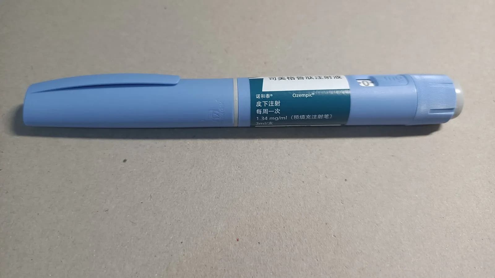 A pale blue Ozempic semaglutide injection pen lying on a grey surface, photographed on 30 June 2023, a file photograph of the comparator drug named in the trial and not of retatrutide, which is not approved
