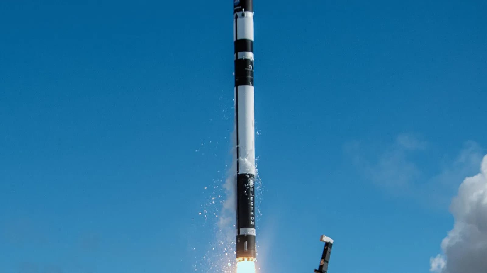 A Rocket Lab Electron rocket lifting off against a blue sky with a plume of exhaust at its base, photographed on 7 May 2023 by NASA and Rocket Lab, a file photograph of the company's smaller Electron and not of the Neutron rocket
