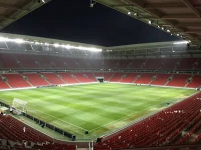 Editorial illustration of an empty floodlit football stadium at night