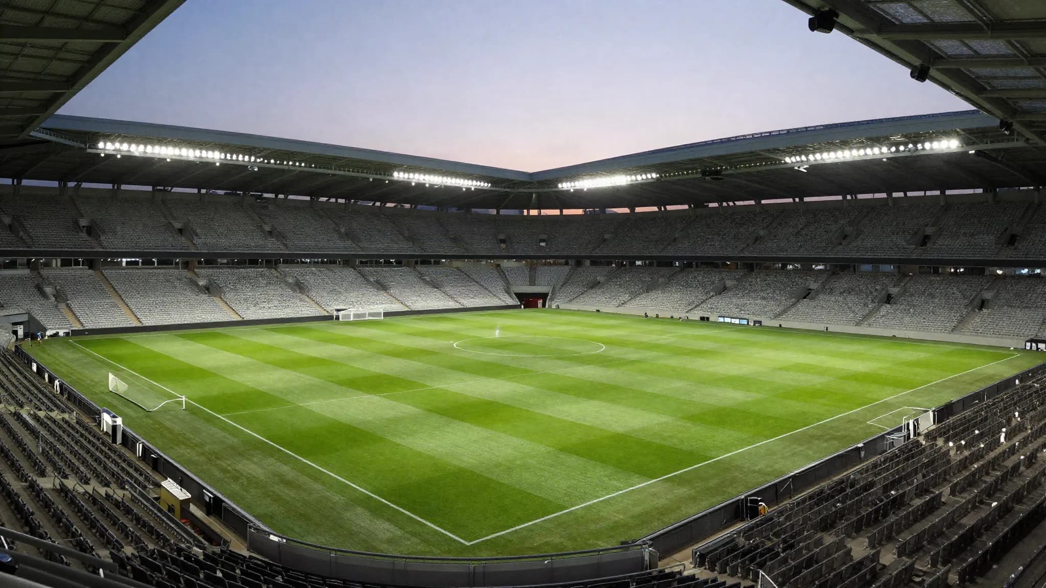 A floodlit football stadium at dusk before kick-off