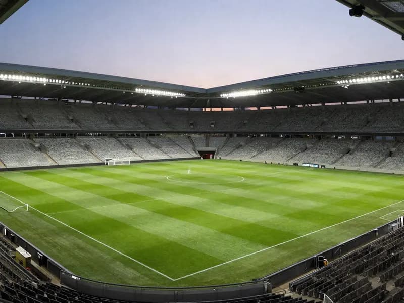 A floodlit football stadium at dusk before kick-off