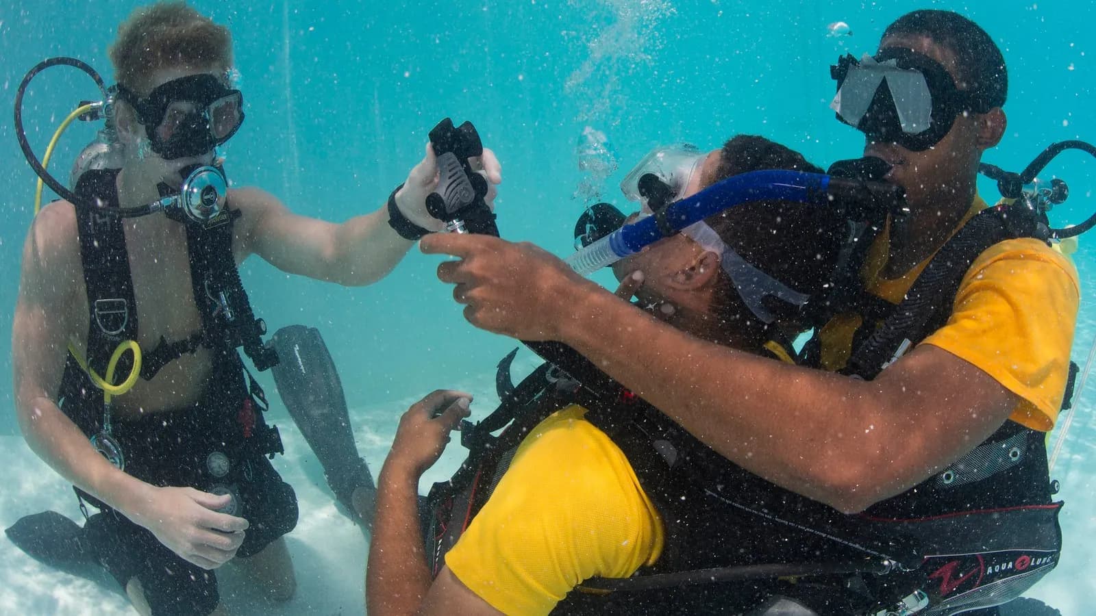 Divers practising scuba emergency procedures in a training pool, in a US Navy photograph from June 2014