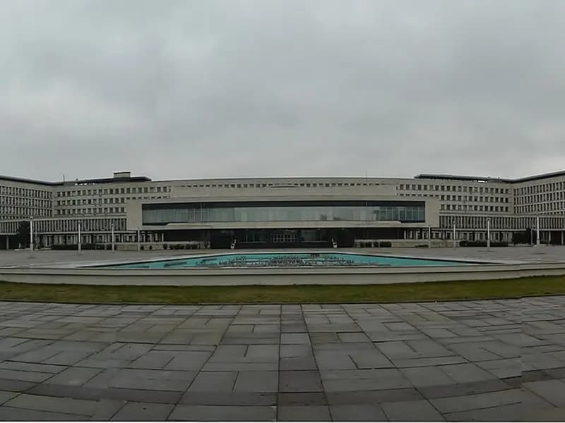 The wide, low, white modernist Palace of Serbia government complex in Belgrade under an overcast sky with a lone pedestrian crossing the plaza, photographed on 30 January 2016, a file photograph of a Belgrade government building and not of the vote count or of any party