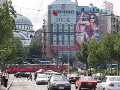 Slavija Square in Belgrade with a red tram, a billboard-covered office block and the dome of the Church of Saint Sava behind it, photographed on 16 June 2009, a file photograph of the square where the rally was held and not of Thursday's crowd