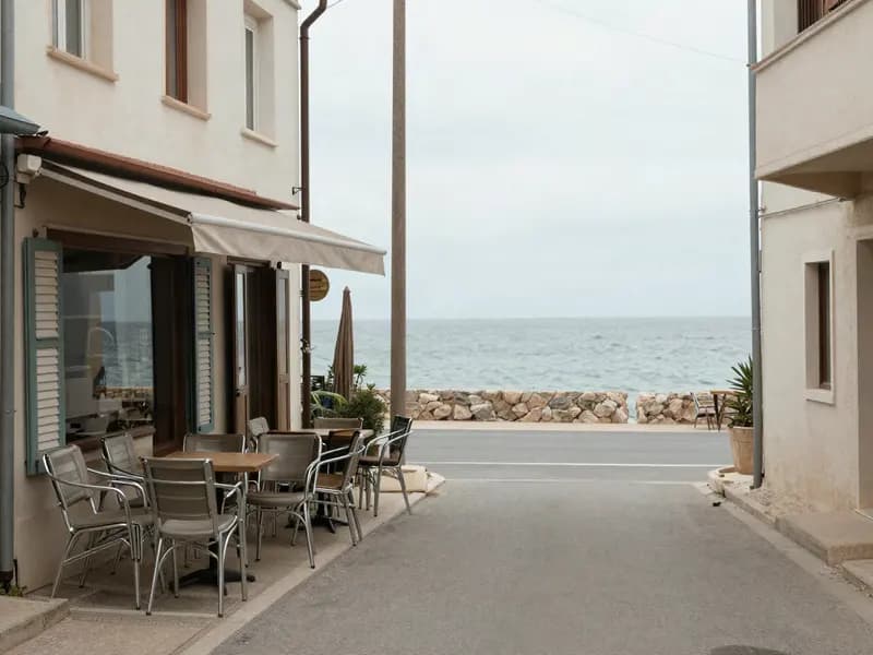 A quiet coastal street out of season with stacked chairs