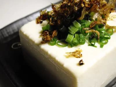 Hiyayakko, a block of cold silken tofu topped with sliced spring onion and fried aromatics, which is the Japanese version of this dish