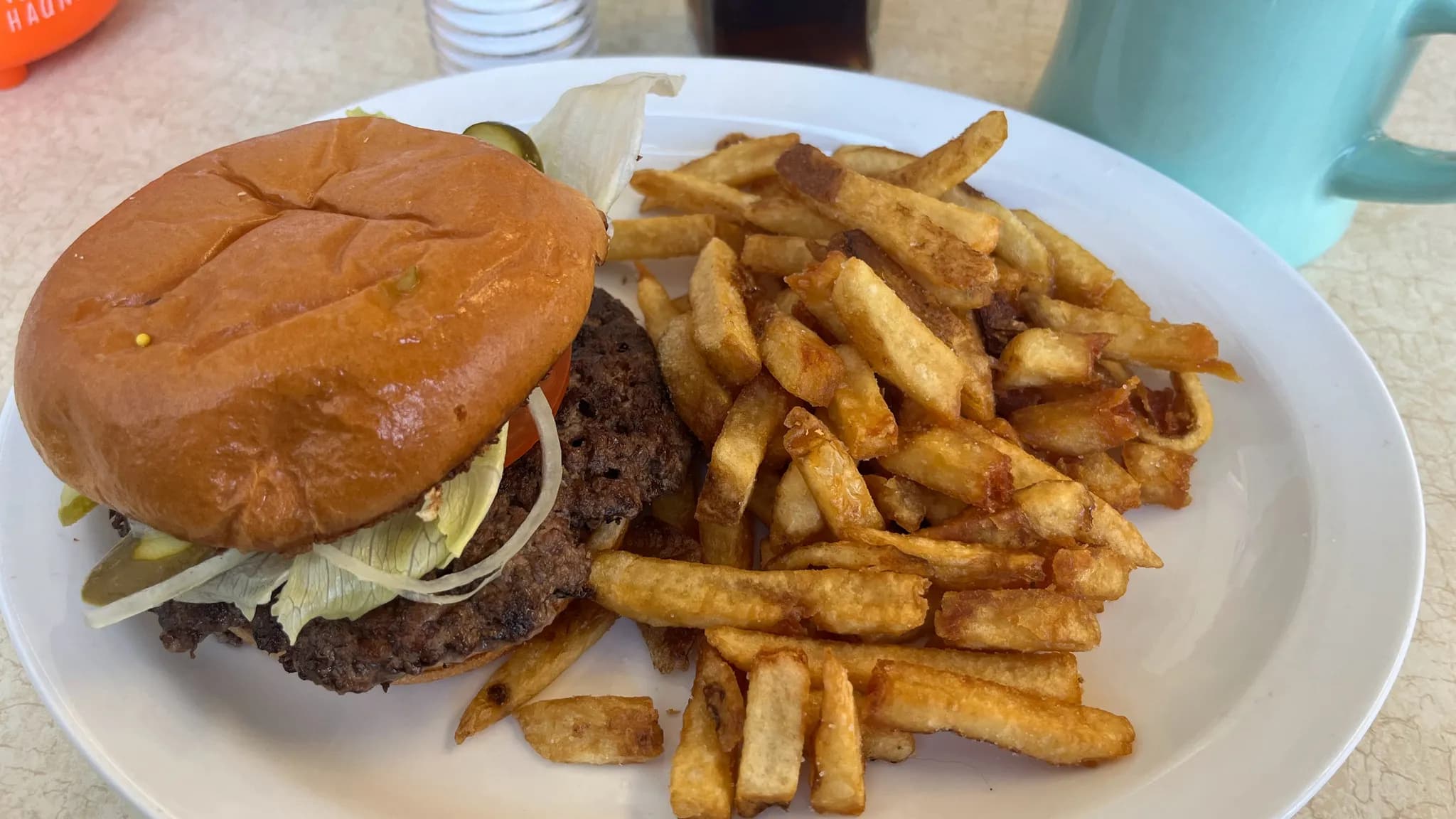 A stacked smash burger with two thin, deeply caramelized crispy-edged beef patties and melted cheese on a toasted bun