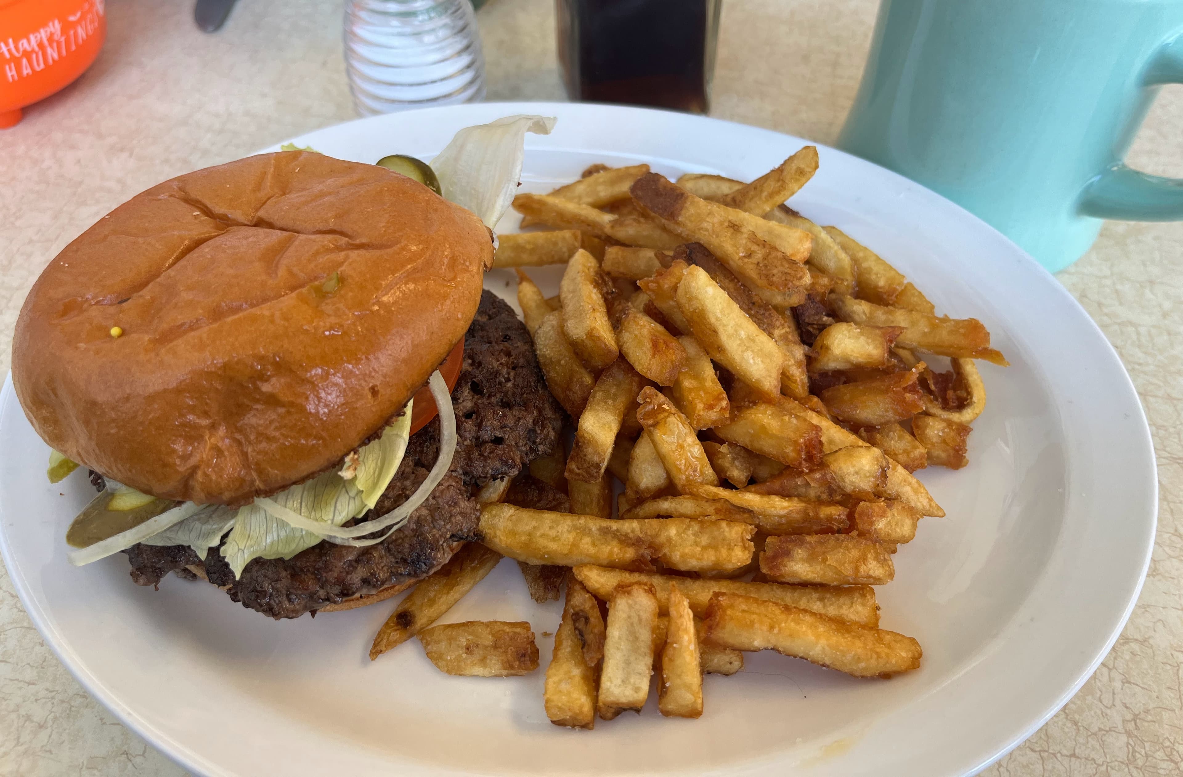 A stacked smash burger with two thin, deeply caramelized crispy-edged beef patties and melted cheese on a toasted bun