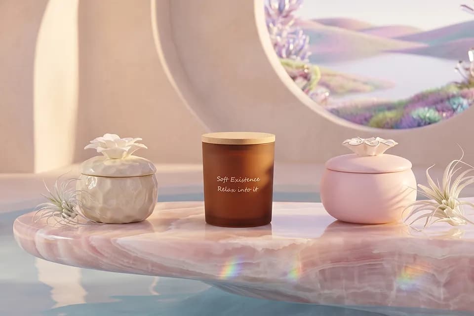Soft Existence candles and ceramic vessels styled on a warm marble surface