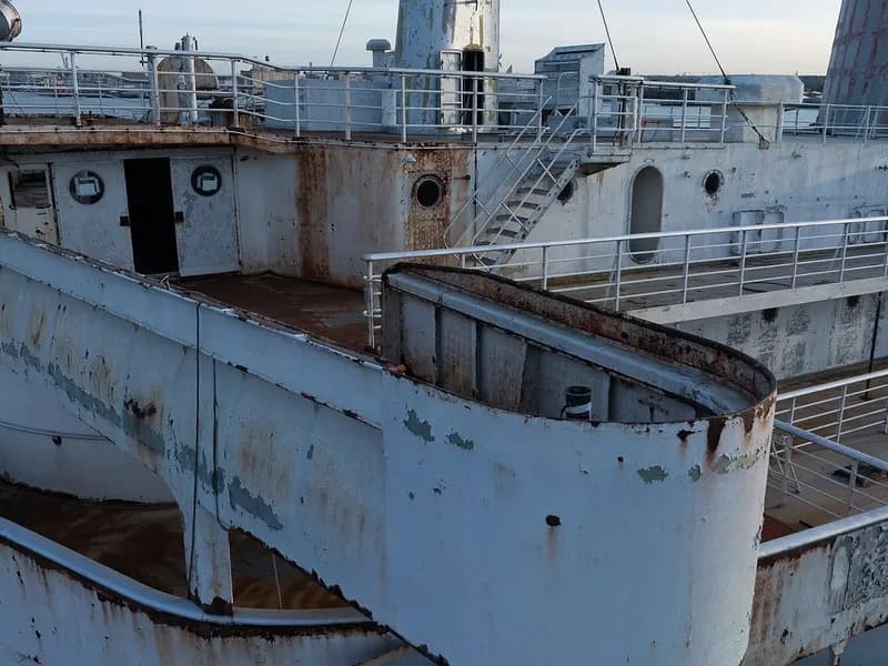 The weathered bridge wing and upper deck of the SS United States, rust-streaked white paint under open sky, photographed on 19 February 2025 on the morning she was towed out of Philadelphia, a file photograph of the ship and not of her preparation or sinking in Florida