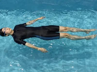 A swimmer floating face down and motionless in a still pool