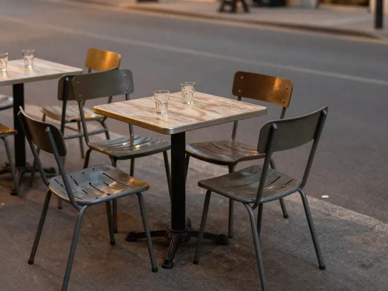 Outdoor cafe tables on a quiet pavement in the evening