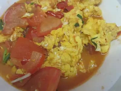 A plate of Chinese stir-fried tomato with scrambled eggs and spring onion, in a Hunan-style home dish, photographed in July 2019