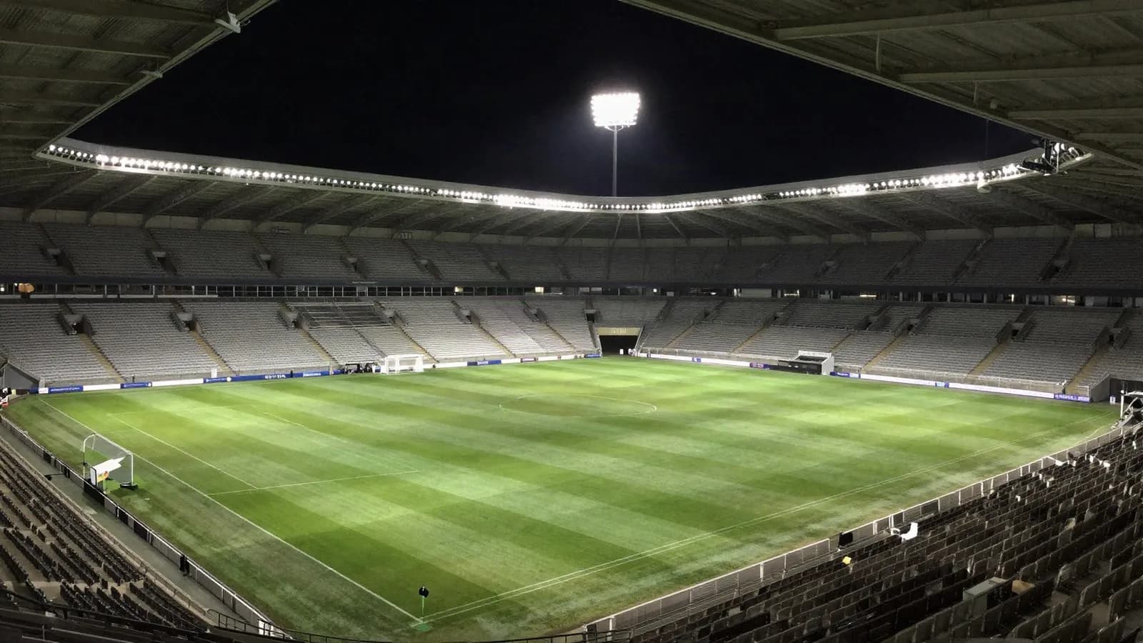 An empty floodlit football stadium before a match