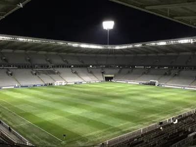 An empty floodlit football stadium before a match