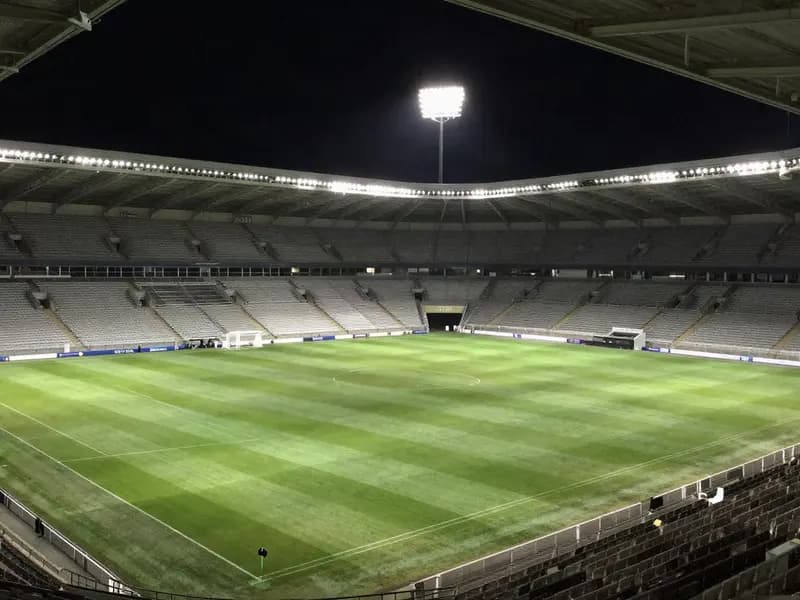 An empty floodlit football stadium before a match