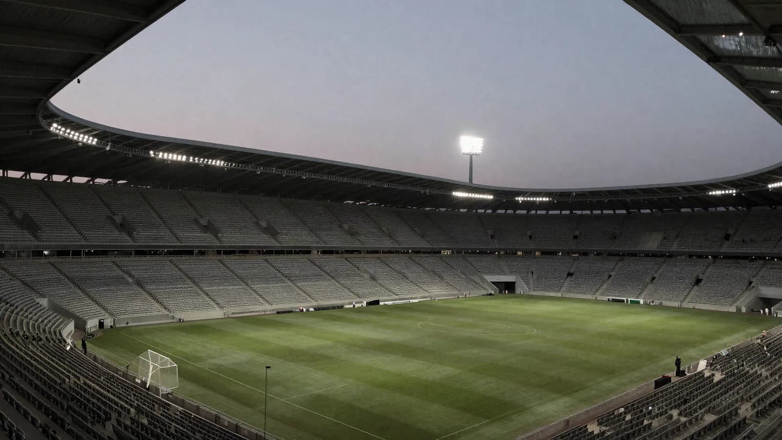 An empty floodlit football stadium in the evening